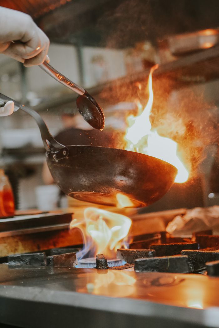 about-us A chef expertly handles a flaming pan in a professional kitchen in Eskişehir, Turkey.